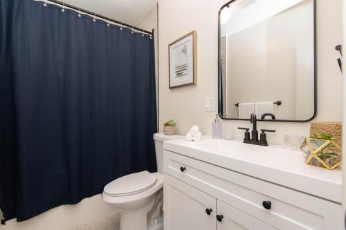 uma casa de banho com um WC e uma cortina de chuveiro azul em Stylish Apartment Near DTLA em Los Angeles