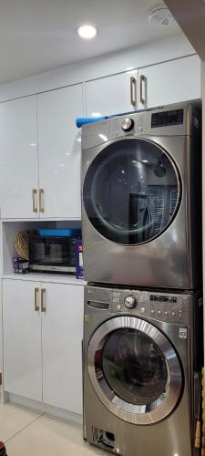 a microwave and a washing machine in a kitchen at Mainfloor Spacious Room in Toronto in Toronto