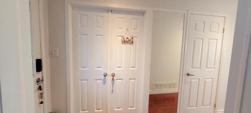 a white closet with two white doors in a room at Main Floor Spacious Room in Toronto in Toronto