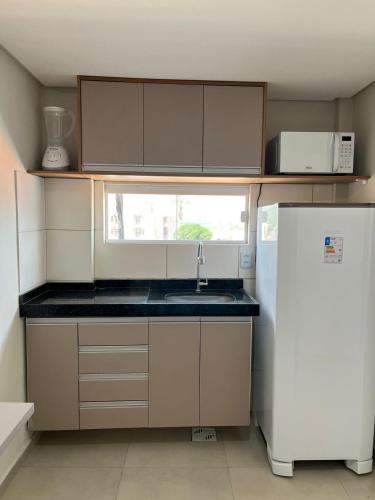 a small kitchen with a sink and a refrigerator at Pousada Prime in Juazeiro do Norte