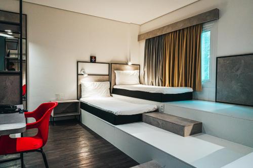 um quarto de hotel com duas camas e uma secretária em ibis Recife Aeroporto no Recife