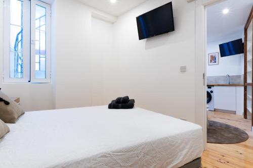 1 dormitorio con 1 cama blanca y TV de pantalla plana en Gibraltar Nest 1-Hosted by Sweetstay, en Gibraltar
