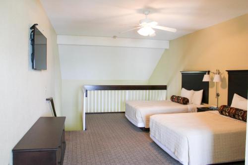 a hotel room with two beds and a table at Kelleys Island Venture Resort in Kelleys Island