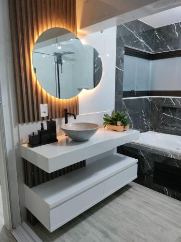 a bathroom with a sink and a large mirror at Suíte Máster Luxo - Lar-Doce-Mar in Barra Velha