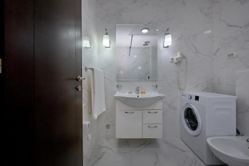 ein weißes Badezimmer mit einer Waschmaschine und einem Waschbecken in der Unterkunft Shine Crystal, first line with a stunning view in Čučići