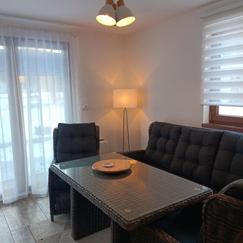 a living room with a table and a couch at Cottage in Słup in Słup
