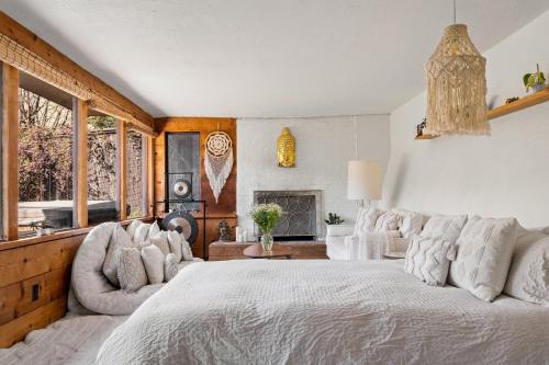 a bedroom with a large white bed and a fireplace at Magical Forest Retreat w Hot Tub, Mt. Tam View, near Muir Woods, 17min to SF in Mill Valley