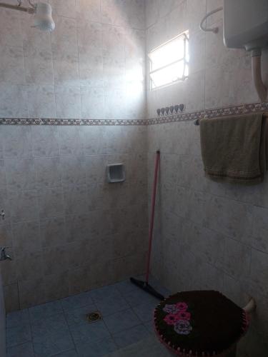 y baño con ducha, trapeador y alfombra. en Hostal Pablito en Encarnación