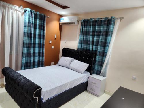 a bedroom with a bed with a black headboard at The Morville Suites and Apartments in Abeokuta