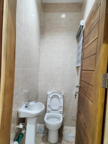 a small bathroom with a toilet and a sink at The Morville Suites and Apartments in Abeokuta