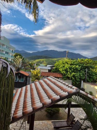 a wooden bench sitting on a patio with mountains in the background at Encantu's Flats in Itatiaia