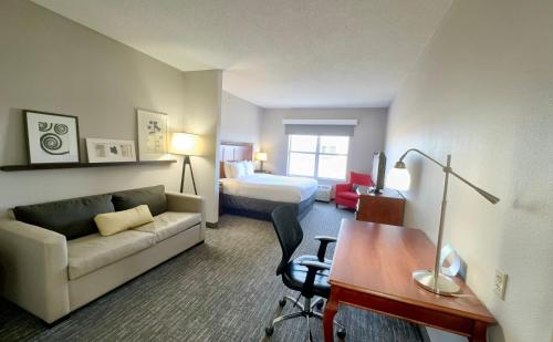 Habitación de hotel con sofá, cama y escritorio. en Country Inn & Suites by Radisson, Harrisonburg, VA, en Harrisonburg