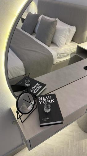 a bedroom with a bed with a mirror and a book at استوديو أنيق مع سطح خاص بحي الملقا in Riyadh