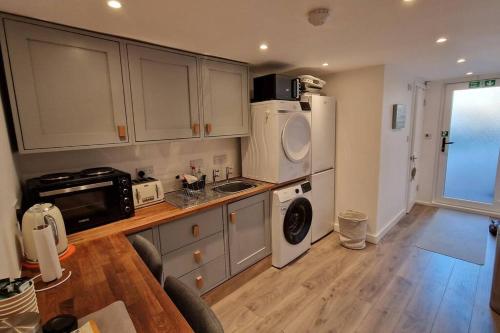 a kitchen with a sink and a refrigerator at Self-contained annex, with parking. in Kent