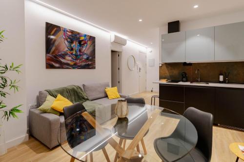 cocina y sala de estar con mesa de cristal en Apartamentos TriBeCa Centro I, en Albacete