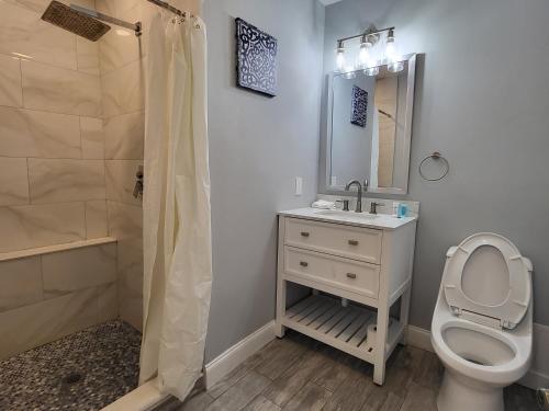 a bathroom with a toilet and a sink and a shower at Barefoot mailman motel in Lantana