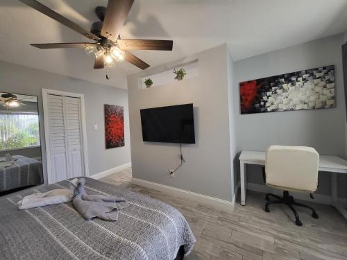a bedroom with a bed and a flat screen tv at Barefoot mailman motel in Lantana