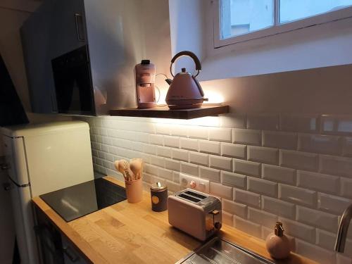 - un comptoir de cuisine avec une bouilloire et un grille-pain dans l'établissement Love Week in Paris, 2 pièces hyper-centre parisien, à Paris
