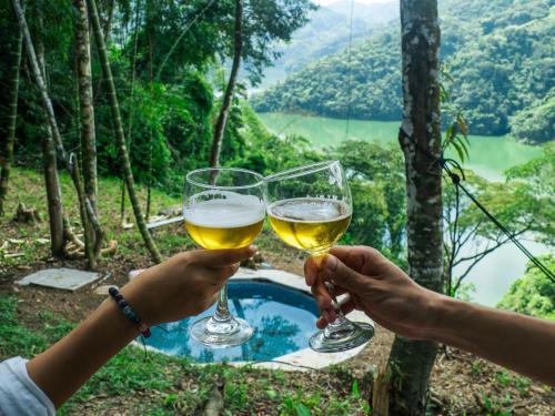 two people holding glasses of white wine overlooking a valley at SELVA ADENTRO in Norcasia