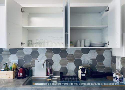 a kitchen with white cabinets and a sink at Appartement parisien 56 m2 neuf, moderne avec 2 chambres, 3 lits, parking gratuit, 15min de Paris et 13 min aéroport Orly in Vitry-sur-Seine