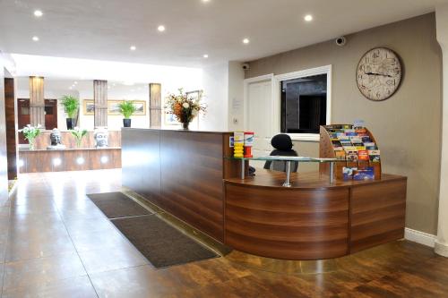 a lobby with a counter with a clock on the wall at The Kings Arms Hotel in Berwick-Upon-Tweed