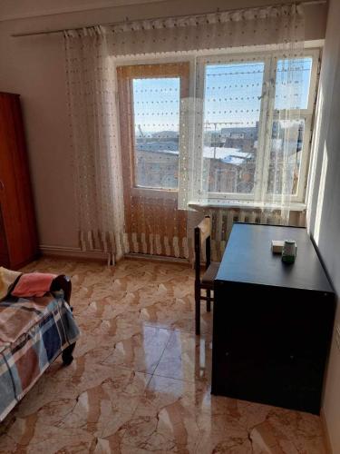 1 dormitorio con escritorio y 2 ventanas grandes en Mazmanyan 181, en Gyumri