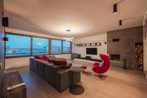 a living room with a couch and a red chair at The View Luxury Residence with Pool in Zadar