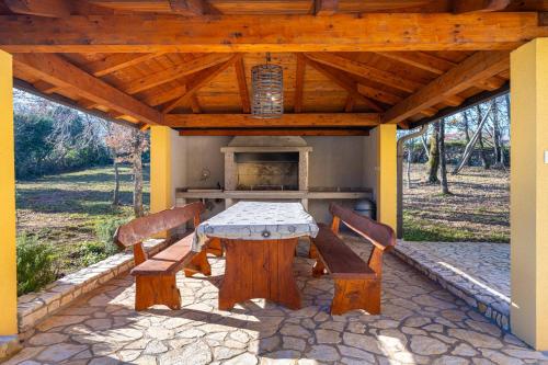 um pátio com uma mesa e 2 cadeiras de madeira em Villa Filleona em Krapan