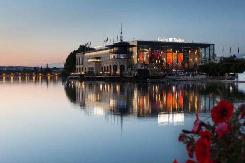 a building sitting on top of a body of water at Appartement Enghien-les-Bains à 7 min du Casino Barrière in Enghien-les-Bains
