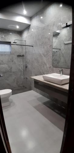 a bathroom with a sink and a toilet and a mirror at RAJVILAS SUITES in Dehradun