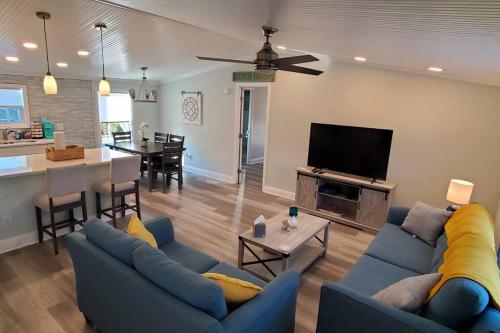 a living room with two blue couches and a dining room at Waterfront home with private dock, walk to beach in Saint Augustine