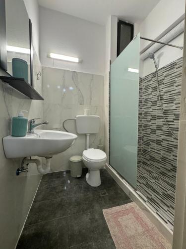 ein Bad mit einem WC, einem Waschbecken und einer Dusche in der Unterkunft Prestige Holiday Apartments in Kos-Stadt