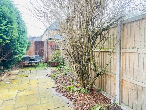 a garden with a fence and a stone walkway at Lovely Dog Friendly, 3 Bed Home Sleeps 8, with Parking & Fenced Garden WORK CONTRACTOR LEISURE, JASPER in Cambridge