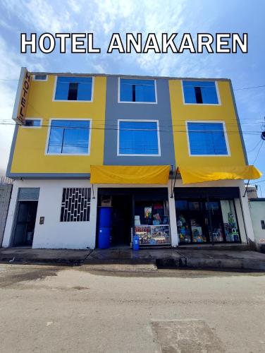 een geel en wit gebouw met een Amerikaans hotel bij Hotel Anakaren Cochera in El Puente