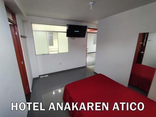 een kamer met een rood bed en een raam bij Hotel Anakaren Cochera in El Puente