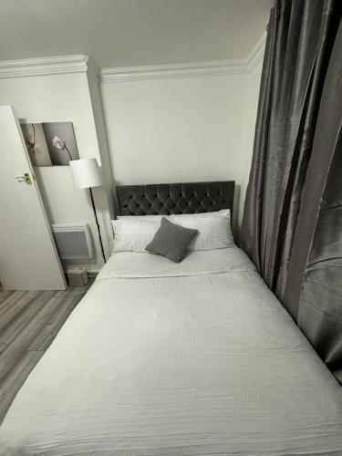 Schlafzimmer mit einem großen Bett mit einem schwarzen Kopfteil in der Unterkunft Cozy studio for your stay in New Southgate