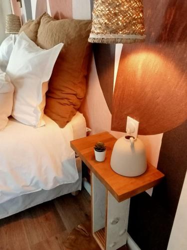 a bed with a table next to a bed with a lamp at les roches du Cabellou 150M de la mer in Concarneau