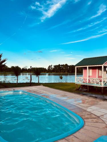 a house with a swimming pool next to a lake at Casa Santa Ana Punta Teco in Santa Ana
