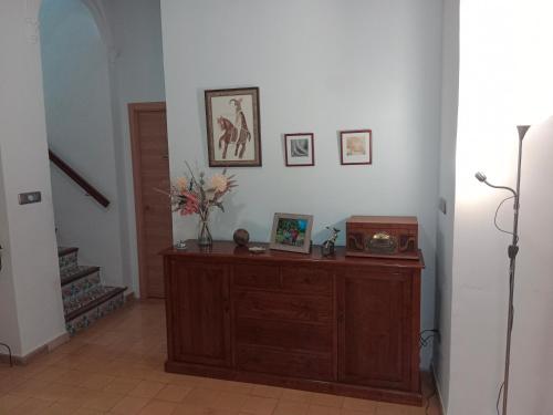 a room with a wooden cabinet with pictures on the wall at La Milotxa in Adsubia