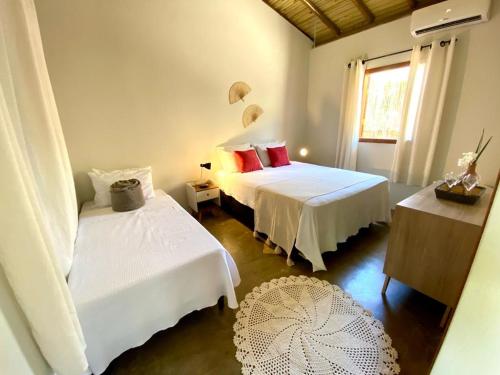 a bedroom with two beds and a window at Recanto Nascer do Sol a 2 km da Praia in Trancoso