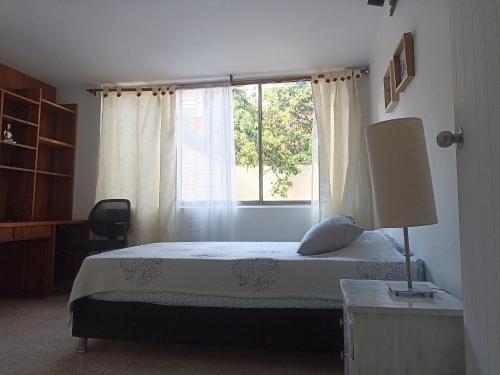 a bedroom with a bed and a window at Habitación laureles la Castellana 2 in Medellín