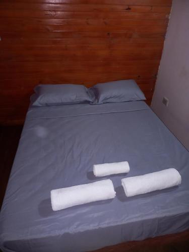 Una cama con dos rollos de toallas. en San Rafael en Puerto Iguazú