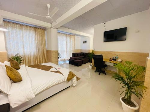 a bedroom with a bed and a tv on the wall at Hotel Relax In - Noida Sector 18 in Noida