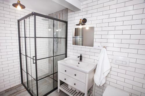 uma casa de banho branca com um lavatório e um chuveiro em Na Chałupki 