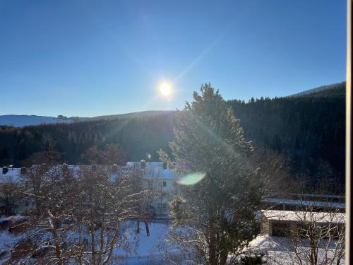 a view of the sun rising over a house in the snow at Fewo Bergblick in Kurort Oberwiesenthal