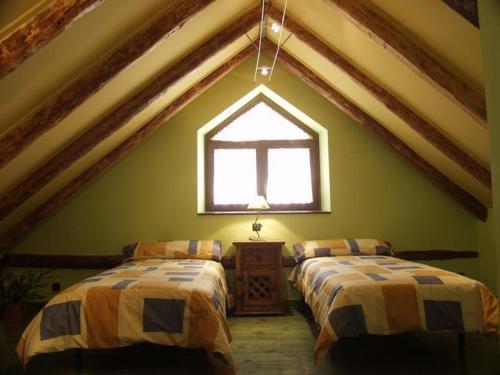 a attic room with two beds and a window at Casa Ramón El Pallé in Sin