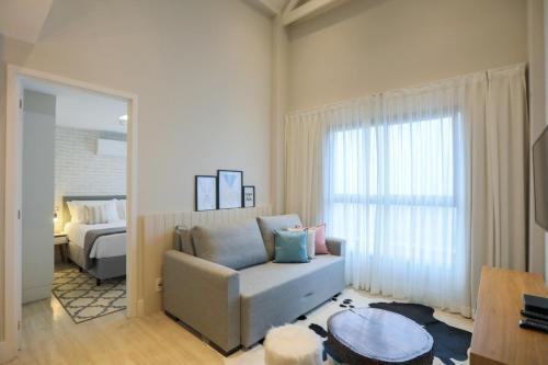 uma sala de estar com um sofá e uma cama em Hotel Carpe Diem Boutique & Spa em Campos do Jordão