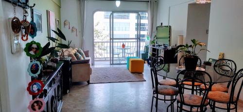 un salon avec une table et des chaises et une cuisine dans l'établissement Apto PITANGUEIRAS SACADA-5Min Praia 1 vaga SERV PRAIA, à Guarujá