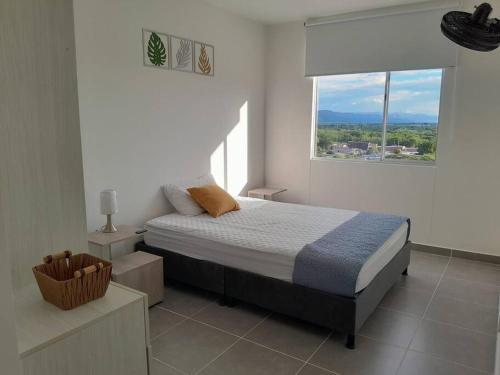 a bedroom with a bed and a large window at Aqualina orange Girardot in Girardot
