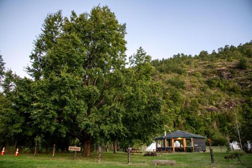 a gazebo in a field next to trees at Amanecer Glamping in llifen